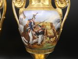 une paire de vases en or ornés de scènes peintes, posés sur une table