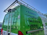 a green van that is parked in the parking lot