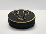 une image représentant une boîte noire sur laquelle sont posées une paire de boucles d'oreilles