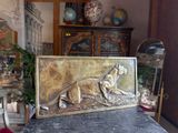 a metal plaque with a dog on it on a table
