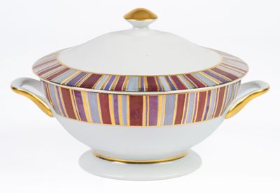 a white bowl with a gold rim and a striped lid