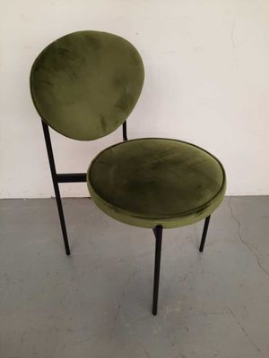 a green chair with black legs and a round seat