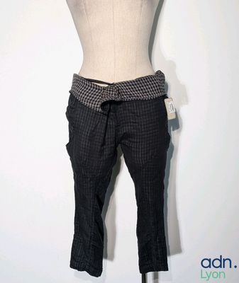 un mannequin sur un pied de mannequin, vêtu d'un pantalon à carreaux noirs et blancs