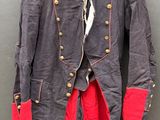 veste grise avec des bordures et des boutons rouges, suspendue à un cintre