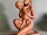 une statue de femme tenant un bébé dans ses bras
