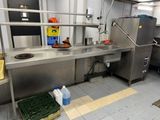 a large stainless steel kitchen with a sink and a refrigerator