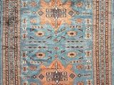 a blue rug with an orange and brown design on it