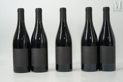 quatre bouteilles de vin sont alignées sur une surface blanche