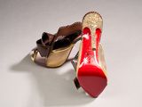 pair of red and gold high heeled shoes on a white surface