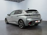 the rear end of a silver car in a white room