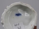 a small white vase with a blue flower in it
