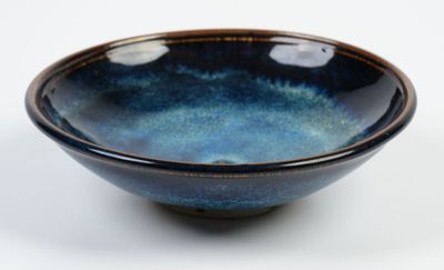 blue and black bowl on a white surface with a white background