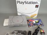 the game console is sitting on the table next to the box