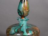 a small glass vase with a flower on the top of it