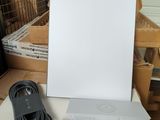 une photo représentant une boîte blanche avec un cordon d'alimentation et un chargeur posés sur une table
