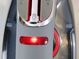 a close up of a silver and red steam iron