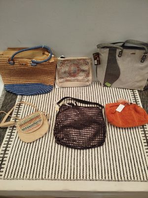 de nombreux sacs et sacs à main posés sur une table au sol