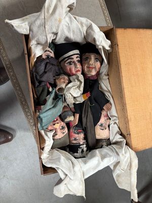 une boîte remplie de poupées posées par terre