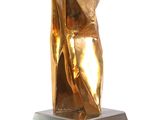 sculpture of a woman in a gold dress sitting on a metal base