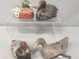 trois canards sont posés sur le dessus d'une vitrine transparente