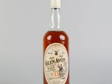 un gros plan d'une bouteille de whisky posée sur une surface blanche