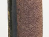 an old book sitting on top of a white table next to a white wall