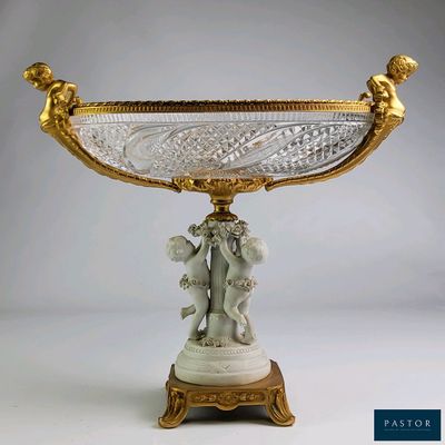un vase doré et blanc surmonté d'une statuette