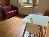 une table et des chaises blanches dans une pièce dotée d'une fenêtre