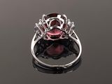 a pink tourmaline and diamond ring on a black surface