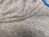 a close up of the back of a gray shirt with blue trim