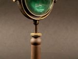 a close up of a green light on top of a wooden stand