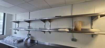 a kitchen with stainless steel shelvings and a window