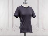 un t-shirt violet sur un mannequin posé contre un mur blanc