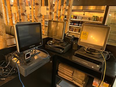 deux ordinateurs de bureau et un ordinateur portable posés sur un bureau dans une pièce