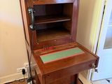 a wooden cabinet with a drawer on top of it