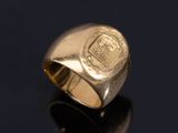 a close up of a gold ring with a crest on it
