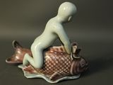 a figurine of a boy sitting on a fish