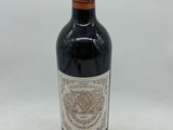 la bouteille de vin rouge est posée sur une surface blanche