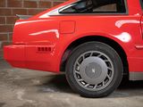a red car parked in front of a brick wall