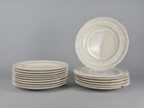 plusieurs assiettes blanches empilées les unes sur les autres sur une surface grise