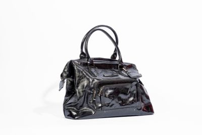 a black purse sitting on a white surface