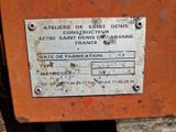 une pancarte apposée sur le flanc d'une machine orange rouillée