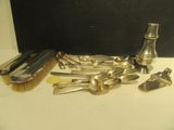 plein de cuillères en argent et une bouteille posées sur une table