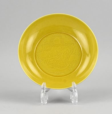 une assiette jaune ornée d'un dragon