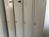 three lockers in the corner of a room with a dog laying on the floor