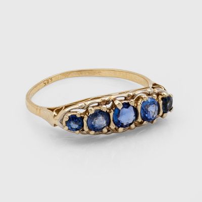 gros plan d'une bague en or avec des saphirs bleus