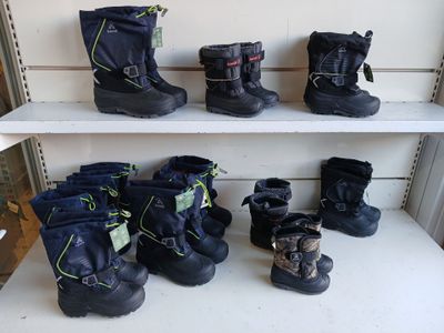 de nombreuses paires de bottes de neige sur une étagère dans un magasin