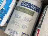 many bags of cement sitting on the ground next to each other