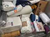 a cart full of bedding and pillows in a store