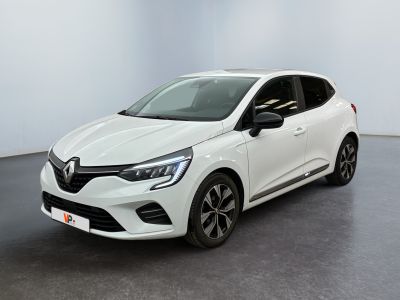 Une voiture blanche est garée dans une pièce au sol noir.